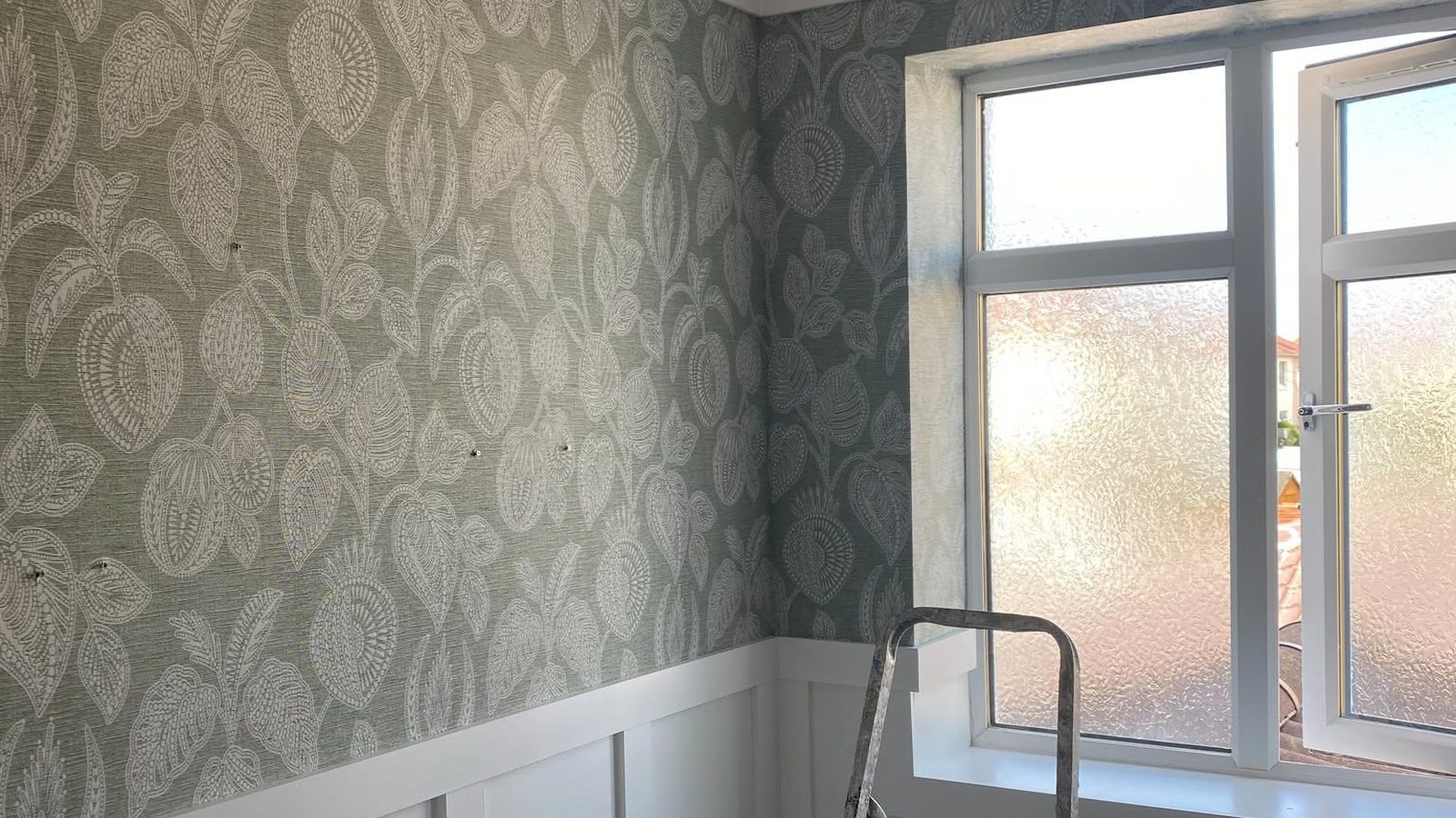 Wallpapered room with ladder mid-job, decorating in Ayr