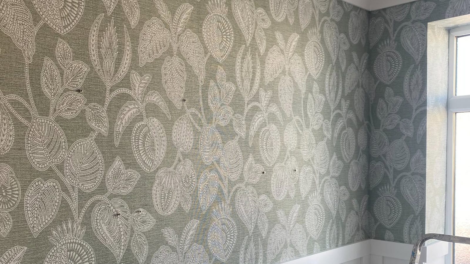 Patterned wallpaper meeting a window reveal, hung by Callaghan Decorators