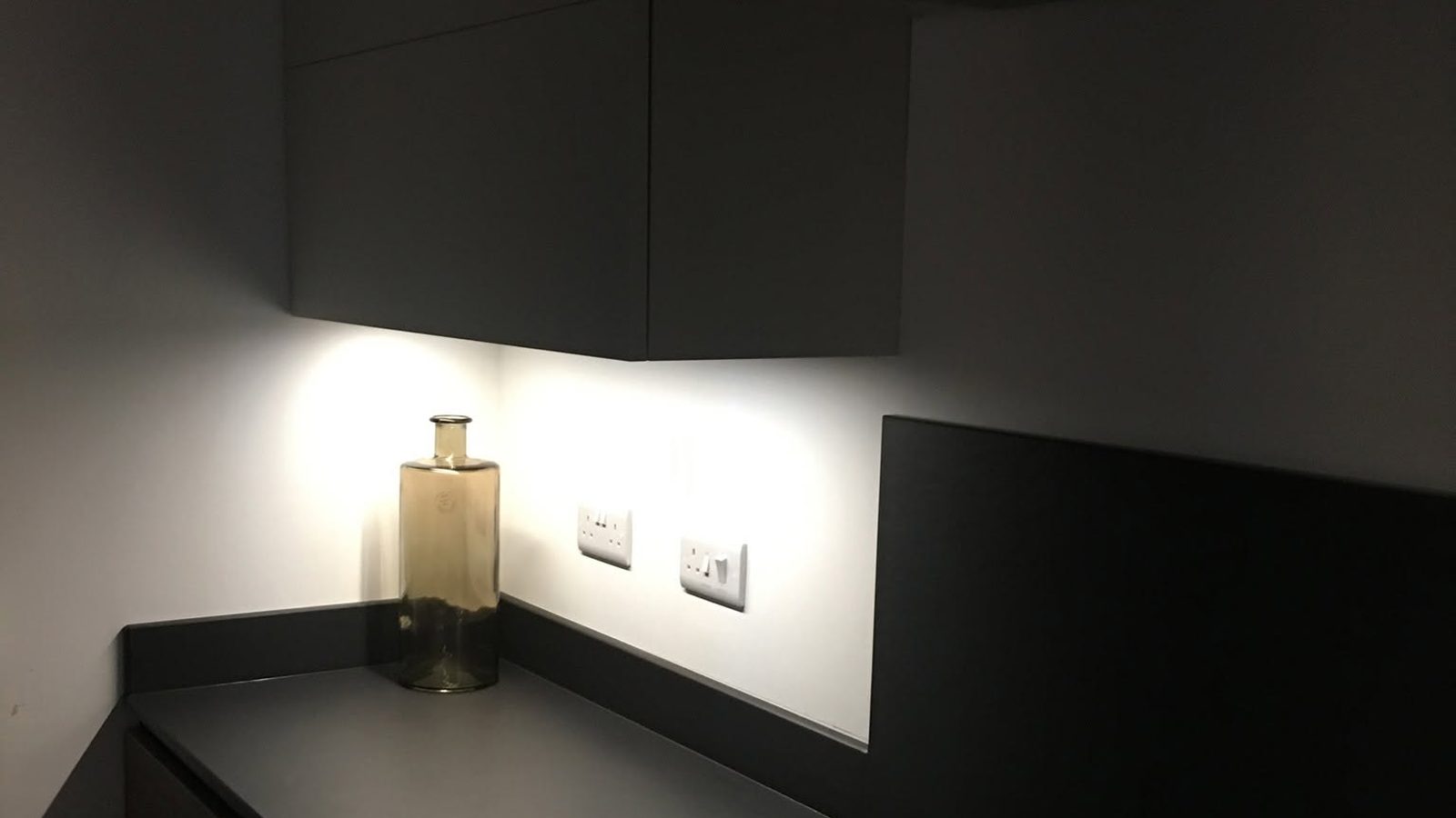 Dark painted kitchen with under-cabinet lighting